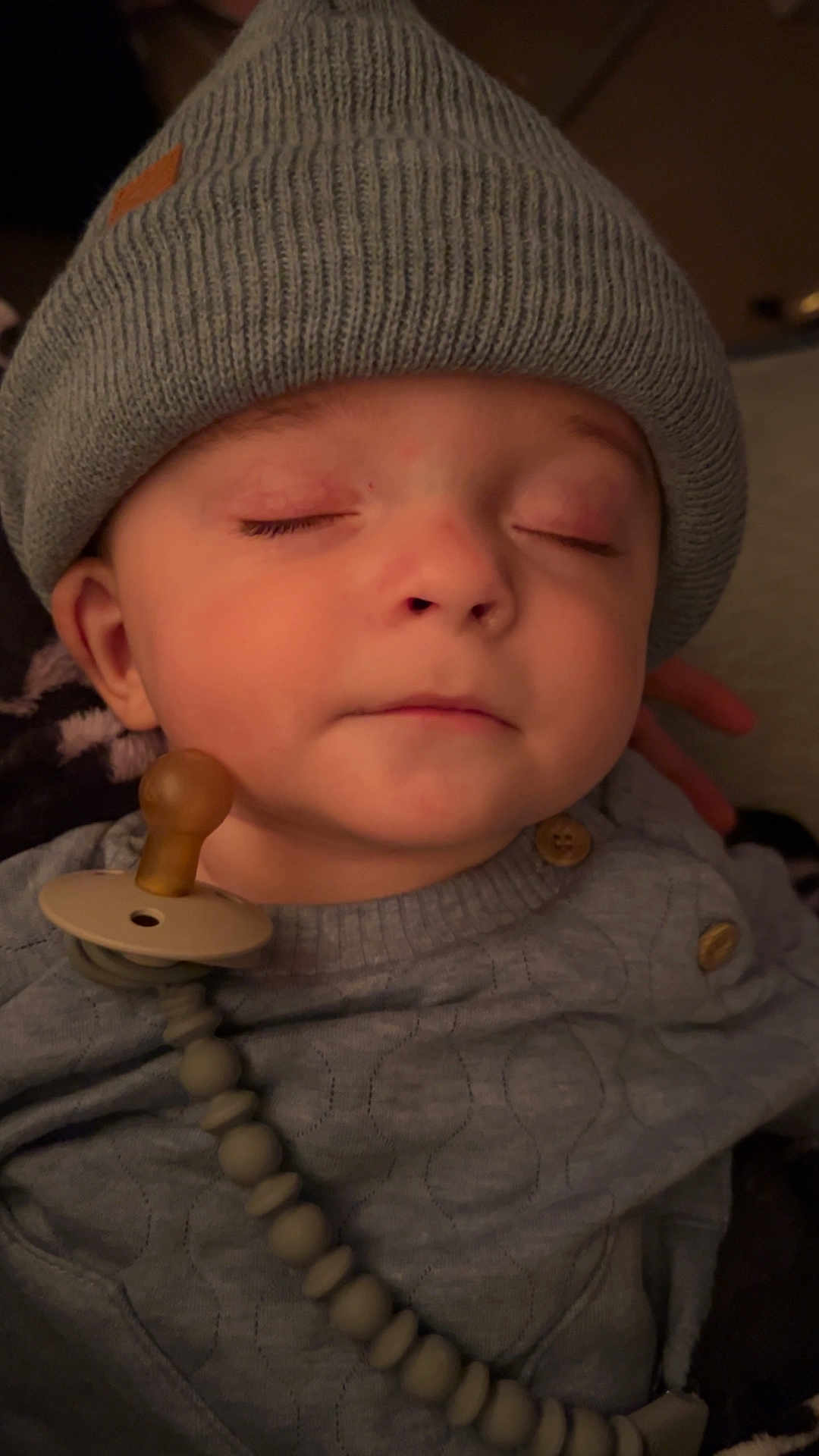 Asher joined the competition — help win amazing prizes! baby, infant, closed_eyes, beanie, pacifier, clothing, sweater, cute, face, headwear, child, sleeping, indoor, soft_lighting, peaceful, adorable, person, hand, cozy, relaxed