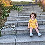 Eva Didar a rejoint le concours — aidez-le/la à gagner de superbes lots ! toddler, child, cat, steps, outdoor, yellow_clothing, smiling, curly_hair, stone, grass, sunlight, happy, sitting, pet, animal, nature, casual, daylight, relaxing, cute