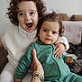 Eva Didar participe au concours pour gagner de l'argent avec cette photo : child, toddler, baby, curly_hair, smile, serious, indoor, couch, hand, pacifier, clothing, green_outfit, white_outfit, bracelet, watch, person, portrait, cute, happy, family