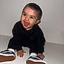 Isaac participe au concours pour gagner de l'argent avec cette photo : baby, child, smiling, sitting, black_clothing, white_socks, sneakers, happy, indoor, portrait, cute, young_child, face, hands, feet, white_background, studio, fashion, expression, infant