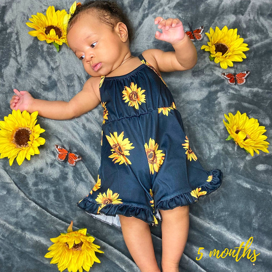 Ily is registered to the contest to win money with this photo: baby_toddler_clothing, beauty, child, facial_expression, finger, flower, fun, gesture, grass, happy, orange, people_in_nature, person, petal, photograph, plant, sleeve, snapshot, t_shirt, toddler