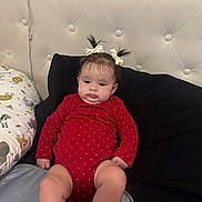 Serenity joined the competition — help win amazing prizes! baby, child, infant, red_onesie, pigtails, bows, pillow, bed, blanket, animal_print, indoor, cute, portrait, sitting, soft_lighting, face, person, clothing, head, expression