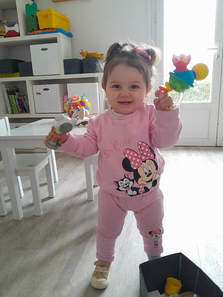 Ange participe au concours pour gagner de l'argent avec cette photo : baby, baby_toddler_clothing, bookcase, child, door, face, floor, flooring, fun, happy, joy, person, play, room, shelf, skin, sleeve, smile, sock, sweatpant