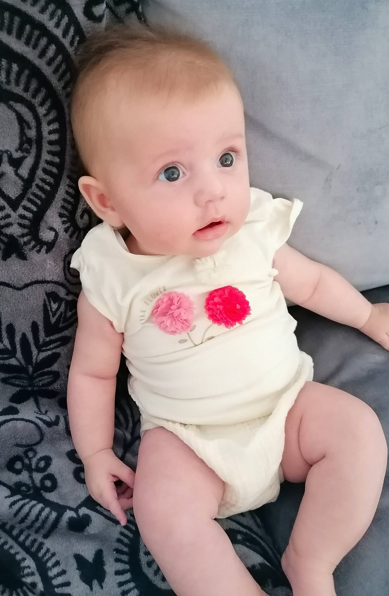 Lana participe au concours pour gagner de l'argent avec cette photo : baby, baby_products, baby_toddler_clothing, cheek, child, eye, finger, head, lip, person, pink, product, sitting, skin, surprise, toddler