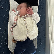 Romy participe au concours pour gagner de l'argent avec cette photo : baby, baby_accessory, baby_girl, changing_pad, child, clothing, cute, dark_pants, face, hand, indoor, infant, lying_down, newborn, pacifier, peaceful, sleepwear, soft_texture, starry_pattern, white_vest