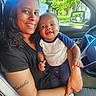 Alexander is registered to the contest to win money with this photo: baby, woman, smile, car_interior, seat, window, greenery, sunlight, tattoo, clothing, holding, portrait, happy, person, infant, socks, steering_wheel, nature, casual, daylight