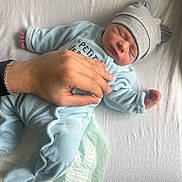 Nael participe au concours pour gagner de l'argent avec cette photo : baby, newborn, sleeping, hand, bracelet, onesie, hat, ear_hat, bed, sheet, infant, cute, soft, peaceful, resting, person, clothing, skin, fingers, sleep