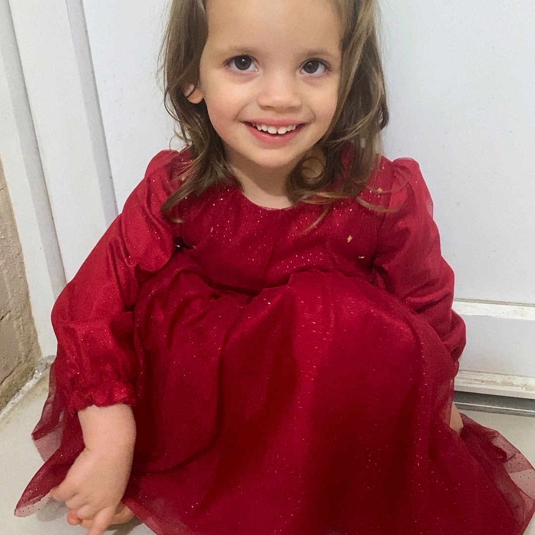 Maëline participe au concours pour gagner de l'argent avec cette photo : child, girl, red_dress, smile, sitting, floor, indoor, portrait, happy, young, cute, long_hair, barefoot, white_background, tile_floor, casual, person, fashion, childhood, joy