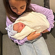 Gracyn is registered to the contest to win money with this photo: child, newborn, baby, blanket, hat, couch, clothing, person, indoor, family, holding, seated, tender, sleeping, cozy, cute, gentle, love, young, portrait