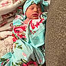 Pru joined the competition — help win amazing prizes! newborn, baby, sleeping, infant, portrait, face, closed_eyes, blanket, swaddle, floral, bow, headwrap, indoors, cozy, carpet, couch, soft_lighting, peaceful, colorful, family_photo