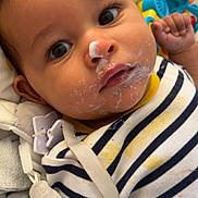Nahïl participe au concours pour gagner de l'argent avec cette photo : baby, infant, face, food, messy, striped_shirt, toy, blanket, curious, lying_down, indoors, close_up, child, skin, hand, clothing, cute, expression, young, portrait
