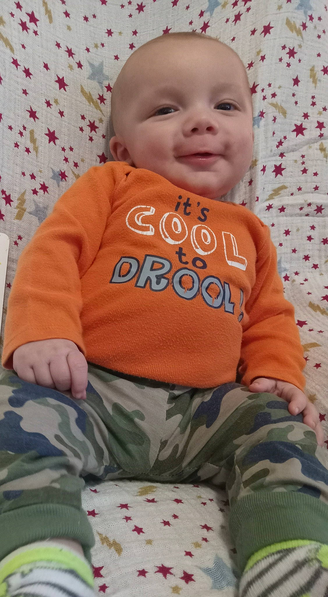 Kolton is registered to the contest to win money with this photo: baby, baby_toddler_clothing, cheek, comfort, cool, face, facial_expression, green, happy, head, joy, nose, orange, organ, person, pink, skin, sleeve, smile, t_shirt