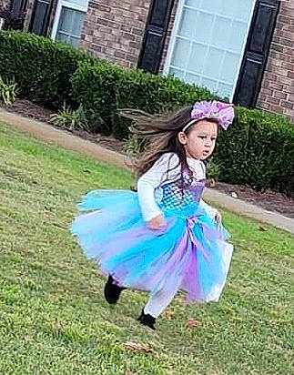 Braeleigh is registered to the contest to win money with this photo: ballet_tutu, child, costume, electric_blue, event, fashion_accessory, fun, garden, grass, grassland, happy, headpiece, headwear, lawn, leisure, magenta, person, plant, recreation, toddler