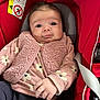 Zoé a rejoint le concours — aidez-le/la à gagner de superbes lots ! baby, infant, car_seat, pink_clothing, floral_pattern, vest, hand, face, eyes, head, seatbelt, red, cute, child, young, portrait, indoors, apparel, person, expression