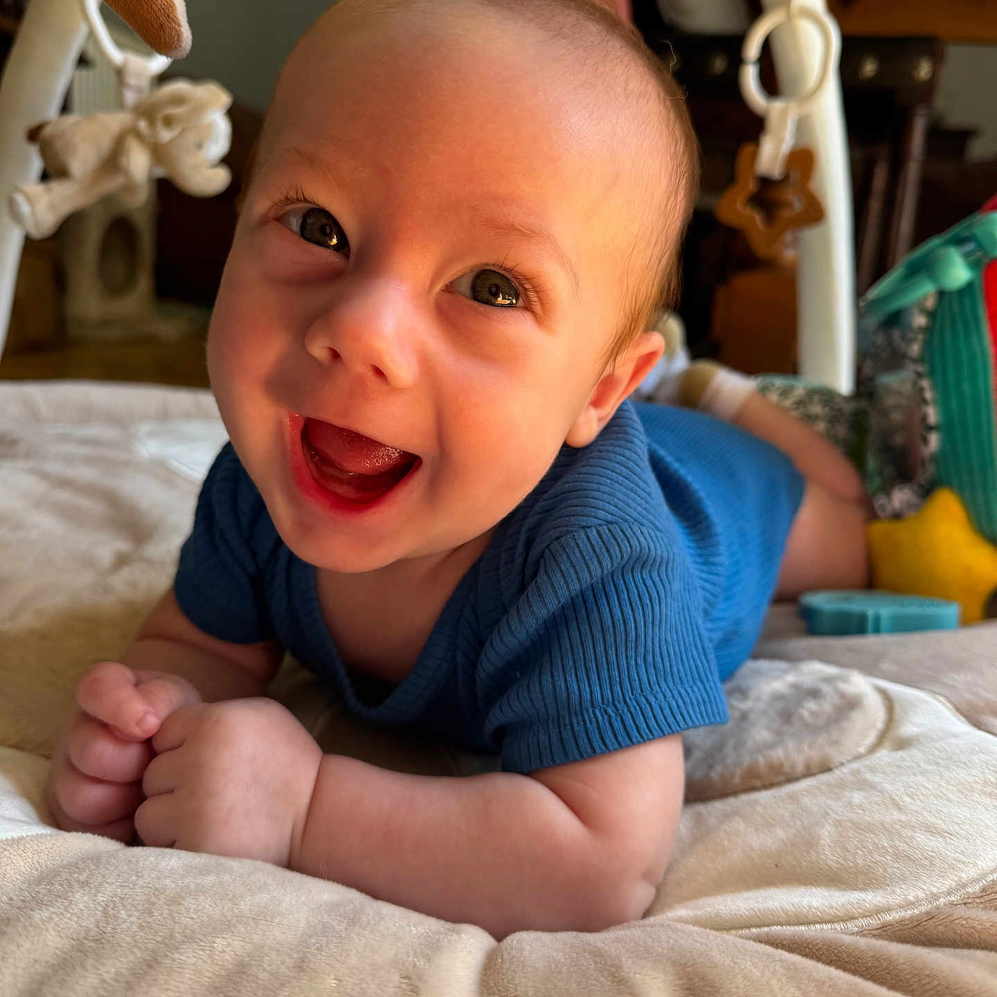Marius a rejoint le concours — aidez-le/la à gagner de superbes lots ! baby, blue_clothing, bright, child, cute, eyes, face, hands, happy, head, indoor, infant, lying_down, play_mat, plush_toys, skin, smiling, soft, tongue, young