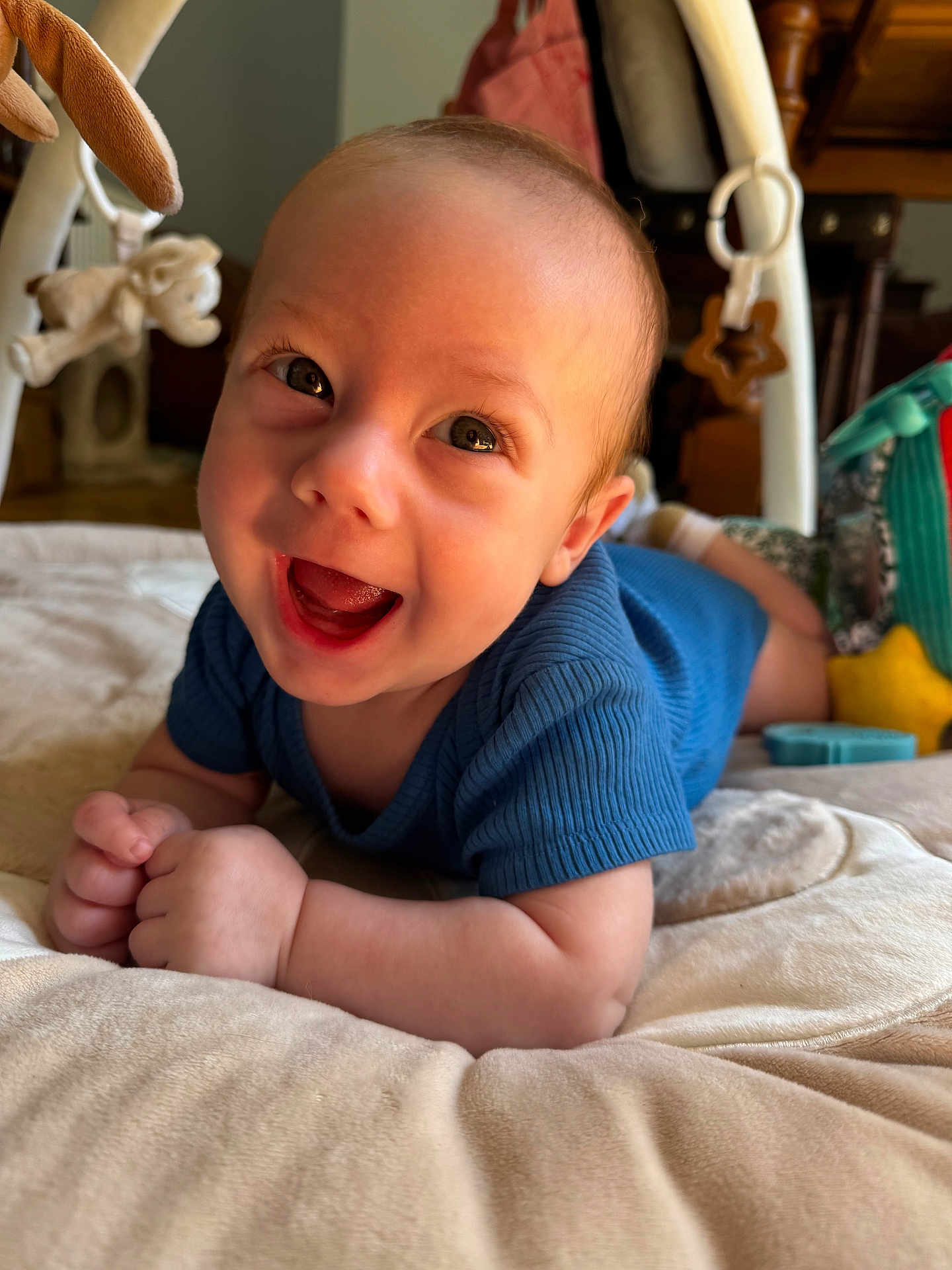 Marius a rejoint le concours — aidez-le/la à gagner de superbes lots ! baby, blue_clothing, smiling, play_mat, plush_toys, infant, face, happy, cute, indoor, child, young, skin, head, hands, lying_down, bright, eyes, tongue, soft