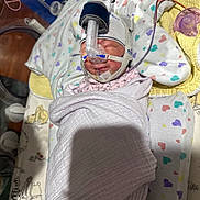 Ayla joined the competition — help win amazing prizes! newborn, baby, hospital, medical_equipment, blanket, swaddled, face, hat, pacifier, tube, heart_pattern, bed, resting, infant, cute, sleeping, healthcare, child, patient, care