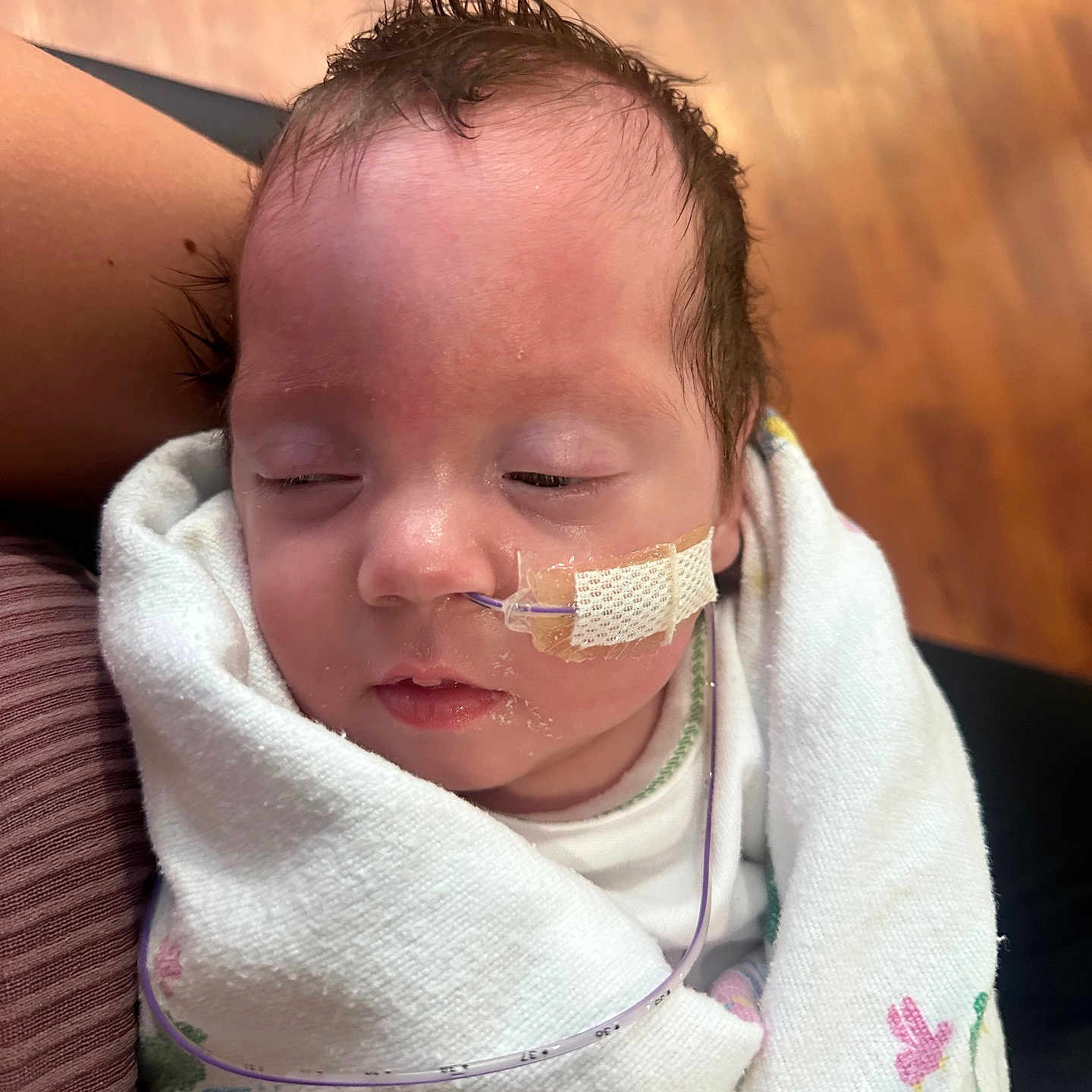 Ayla joined the competition — help win amazing prizes! baby, infant, sleeping, blanket, medical_tube, face, hair, cheek, skin, person, newborn, indoors, soft_texture, wrapped, closeup, peaceful, tape, healthcare, head, resting