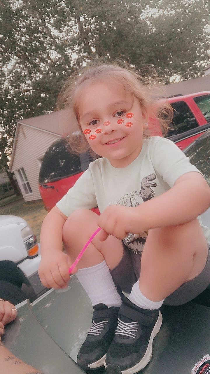 Abel is registered to the contest to win money with this photo: child, smile, face_filter, outdoor, car, vehicle, tree, house, sneakers, socks, shorts, tshirt, playful, happy, person, daylight, nature, suburb, casual, cute