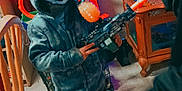 Abel is registered to the contest to win money with this photo: child, hoodie, toy_gun, goggles, indoor, carpet, fish_tank, wooden_chair, curtains, person, furniture, mask, shoes, sleeves, window, floor, room, play, kid, casual