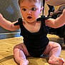 Naveah joined the competition — help win amazing prizes! baby, child, sitting, black_outfit, wooden_floor, indoor, curious_expression, arms_raised, barefoot, stroller, patterned_wall, cute, infant, person, plump, skin, flooring, young, one_person, indoors