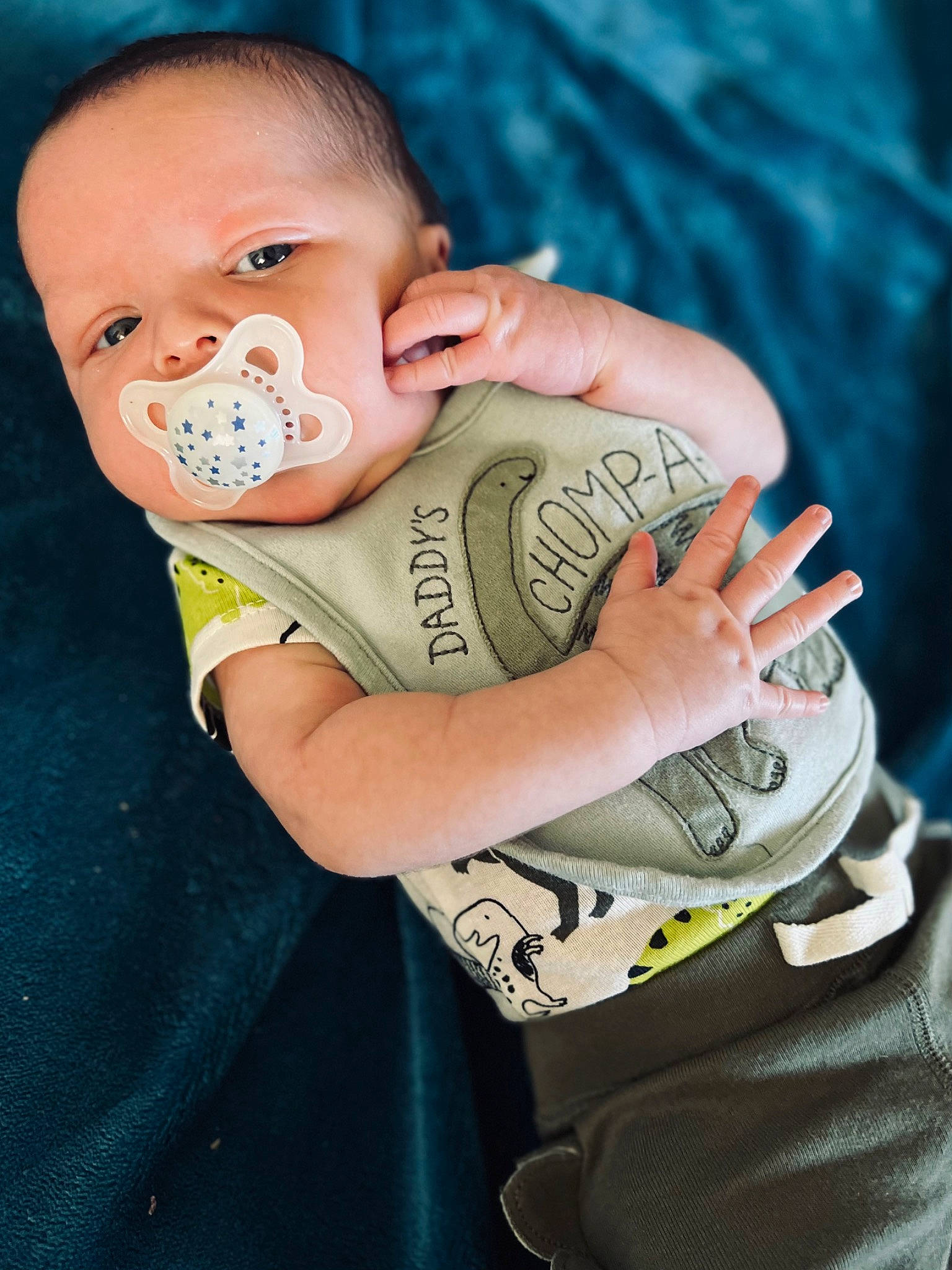 Maverick is registered to the contest to win money with this photo: arm, baby, baby_toddler_clothing, cheek, child, cool, elbow, eye, eyelash, finger, flash_photography, fun, gesture, grass, happy, person, personal_protective_equipment, sitting, t_shirt, thumb