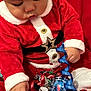 Jayden participe au concours pour gagner de l'argent avec cette photo : baby, child, santa_claus_costume, red_clothing, white_fur_trim, christmas_ornaments, decorations, ribbons, holiday, festive, cute, indoors, portrait, sitting, hand, face, headwear, soft_texture, seasonal, celebration