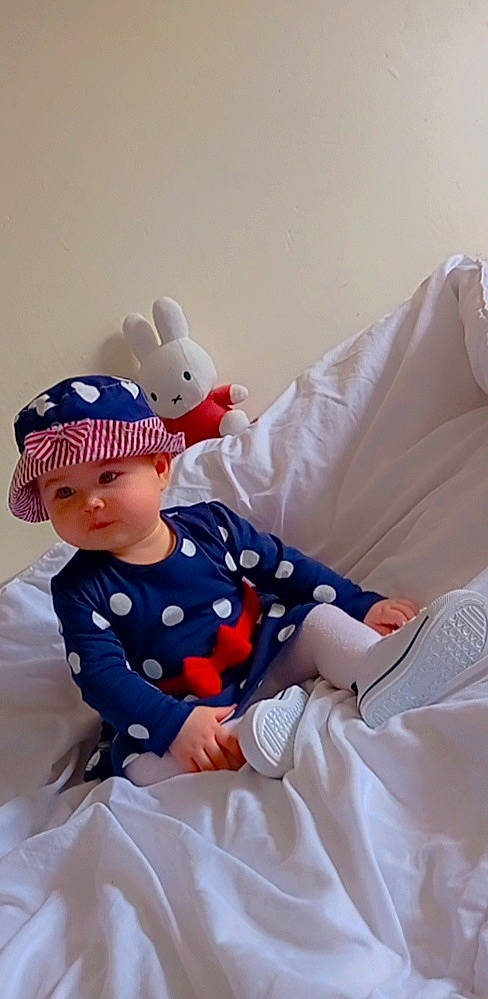 Alya a rejoint le concours — aidez-le/la à gagner de superbes lots ! baby, baby_products, baby_toddler_clothing, bedding, cap, child, comfort, doll, electric_blue, headwear, linens, pattern, person, pillow, play, room, sitting, sleeve, t_shirt, textile