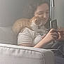 Arthus participe au concours pour gagner de l'argent avec cette photo : person, kitten, cat, couch, smartphone, indoor, relaxing, shoulder, white_shirt, curly_hair, striped_pants, light, wall, home, pet, casual, seated, comfort, technology, interaction