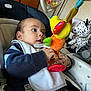 Hakan a rejoint le concours — aidez-le/la à gagner de superbes lots ! baby, baby_seat, bib, chicco, child, closeup, colorful, comfort, curious, face, hand, indoor, infant, person, playing, plush_toy, seat, striped_sweater, toy, young_child