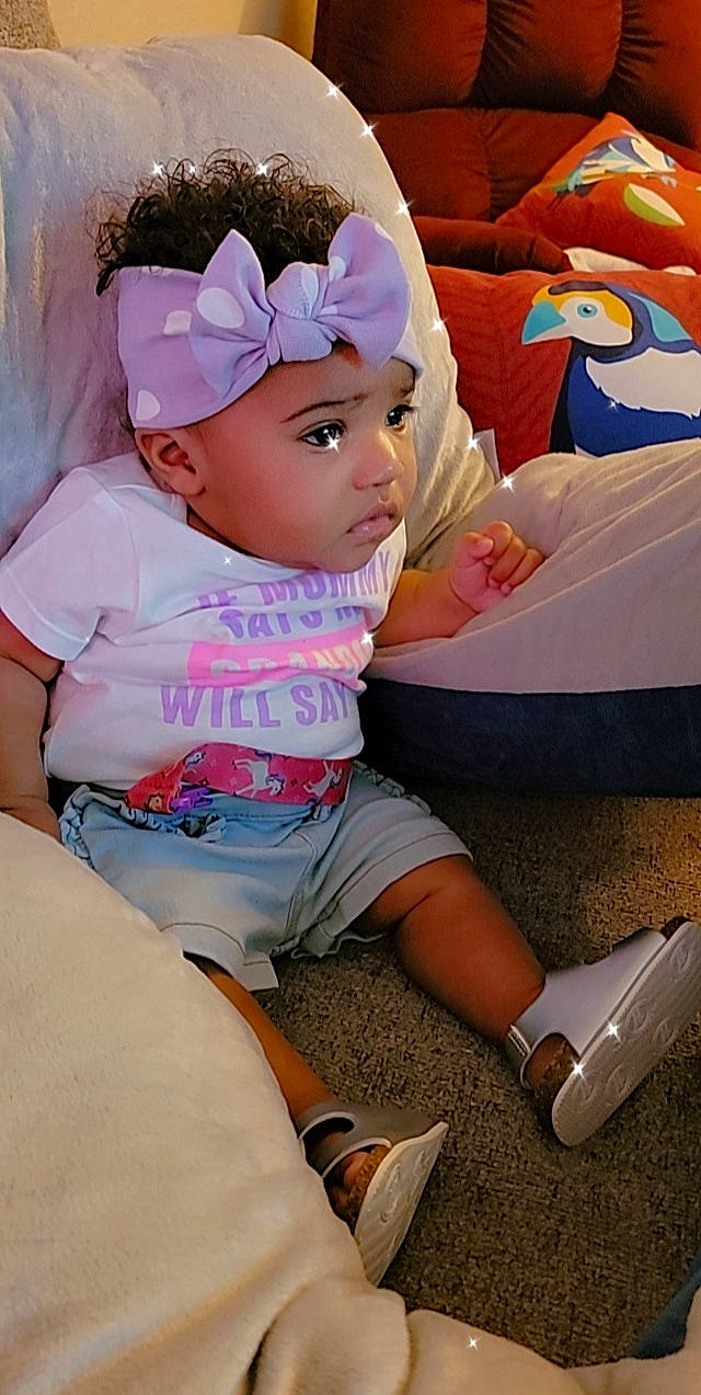 Legacy is registered to the contest to win money with this photo: baby, baby_toddler_clothing, bird, cap, child, event, fashion_accessory, foot, fun, happy, headwear, human_leg, knee, leisure, magenta, person, pink, play, sandal, sitting