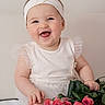 baby, smiling, headband, flower, roses, bouquet, white_clothing, happy, cute, infant, portrait, sitting, hands, feet, skin, indoors, soft_light, tulle, flower_decoration, child