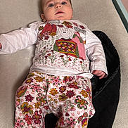 Sofia a rejoint le concours — aidez-le/la à gagner de superbes lots ! baby, child, infant, clothing, floral_pattern, pants, shirt, face, foot, hand, changing_table, indoor, curious, person, cute, lying_down, skin, head, earrings, colorful