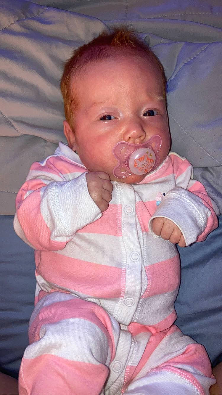 Savanna is registered to the contest to win money with this photo: arm, baby, baby_toddler_clothing, cheek, comfort, eye, eyebrow, gesture, hand, head, human_body, iris, lip, mouth, neck, nose, person, pink, skin, sleeve