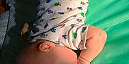 Isaiah joined the competition — help win amazing prizes! baby, infant, onesie, truck_pattern, padded_mat, lying_down, thumb_sucking, soft_light, indoor, child, cute, sleepy, skin, head, arm, leg, foot, clothing, patterned_clothing, peaceful
