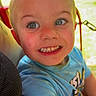 Stefan is registered to the contest to win money with this photo: child, boy, toddler, smiling, grinning, portrait, face, blue_shirt, short_hair, teeth, outdoor, sunlight, park, greenery, red_chair, seated, closeup, happy, playful, photography