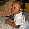 Khyren is registered to the contest to win money with this photo: child, toddler, baby, portrait, sitting, couch, sofa, pillow, indoor, home, white_shirt, bow_tie, striped_shorts, hands, profile, looking_sideways, adult, family, furniture, cozy