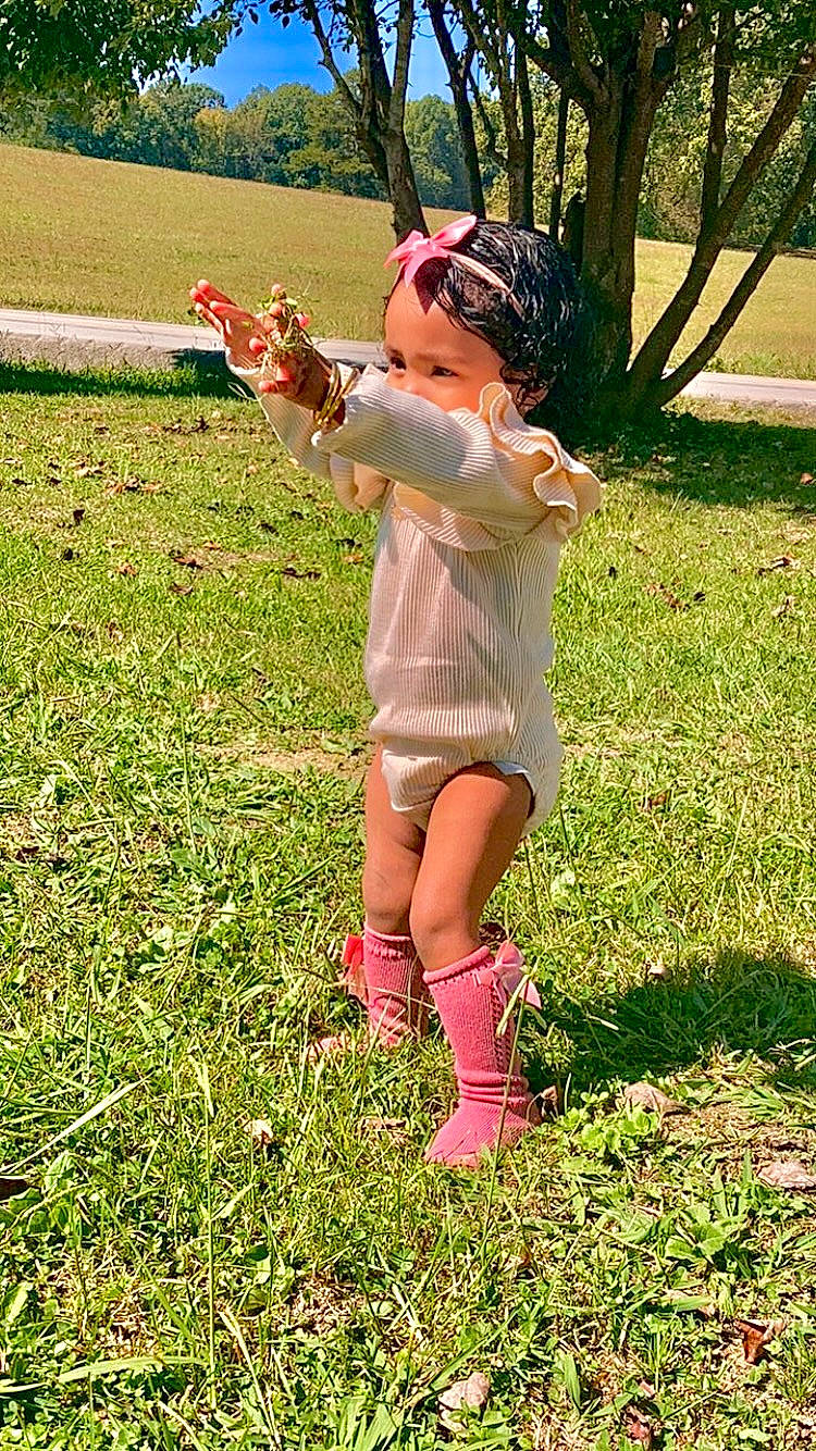 Davina joined the competition — help win amazing prizes! baby, finger, gesture, grass, grass_family, grassland, hand, happy, hat, human_leg, knee, lawn, meadow, people_in_nature, person, plant, sunlight, thigh, thumb, toddler