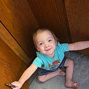 Owen joined the competition — help win amazing prizes! barefoot, blue_shirt, cabinet_door, carpet, child, curious, cute, floor, furniture, happy, home_interior, indoor, person, playful, sitting, small_child, smiling, toddler, wooden_cabinet, young_child