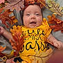 autumn, baby, baby_boy, baby_girl, child, closeup, cozy, cute, fall_leaves, happy, indoors, infant, leaf_decoration, nature_theme, playful, portrait, seasonal, smiling, soft_lighting, yellow_clothing