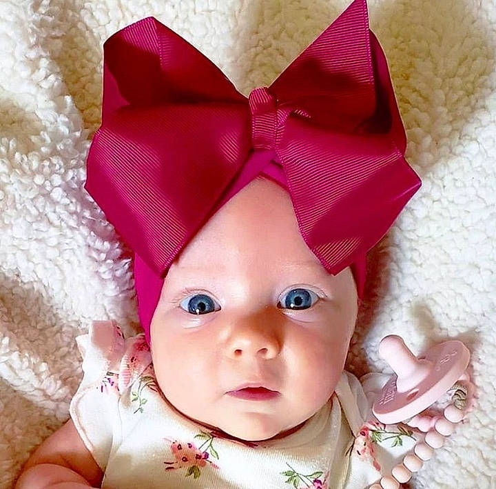 Chandler joined the competition — help win amazing prizes! baby, beauty, cheek, child, close_up, ear, eye, face, forehead, hair_accessory, hand, head, headgear, headwear, lip, mouth, nose, outerwear, person, pink