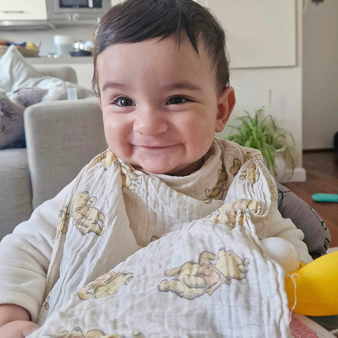 Imran Samy Shah a rejoint le concours — aidez-le/la à gagner de superbes lots ! baby, baby_seat, blanket, child, clothing, couch, cute, face, furniture, happy, home, indoors, infant, living_room, person, plant, portrait, smiling, teddy_bear_prints, young_child
