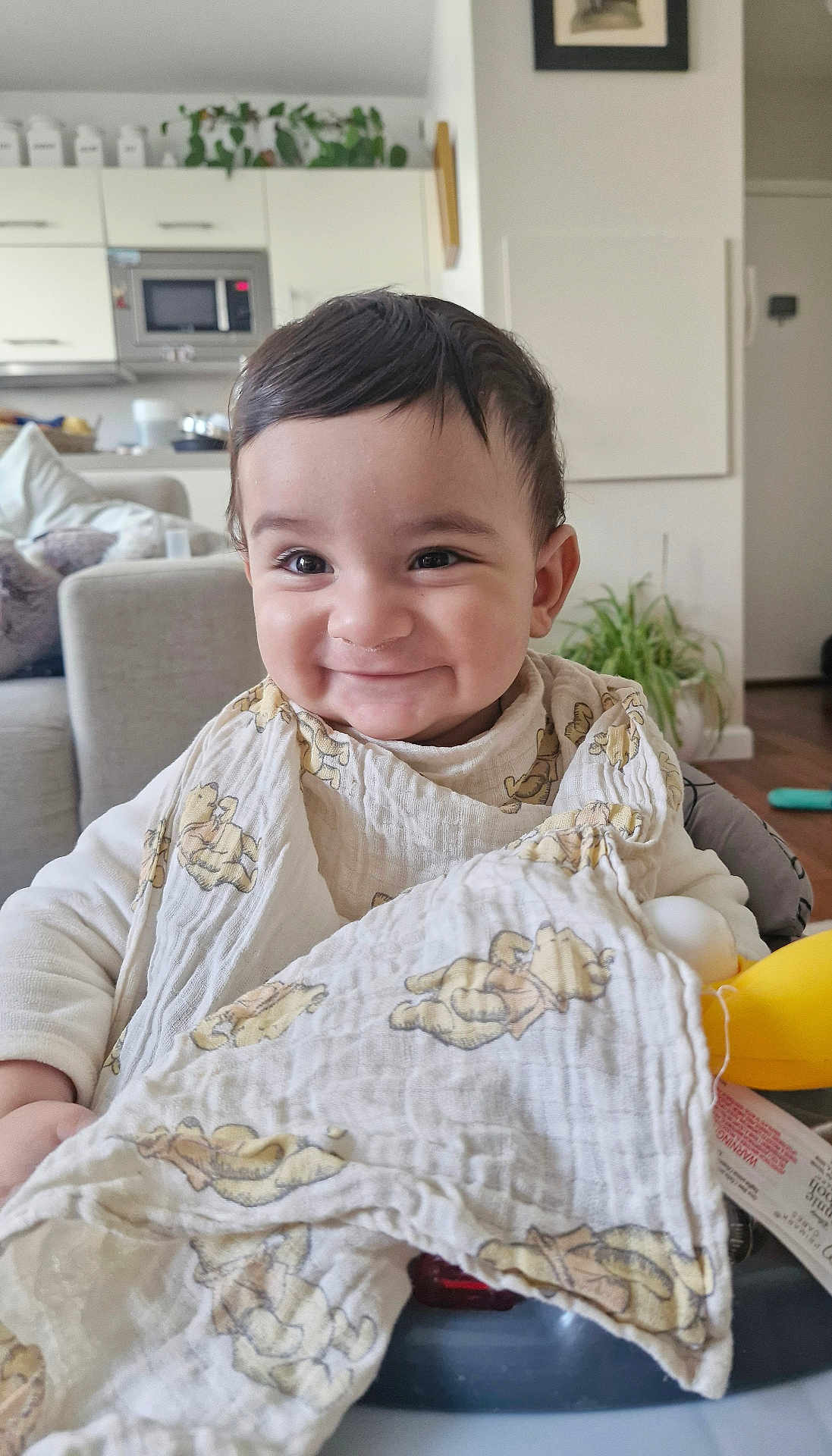 Imran Samy Shah a rejoint le concours — aidez-le/la à gagner de superbes lots ! baby, baby_seat, blanket, child, clothing, couch, cute, face, furniture, happy, home, indoors, infant, living_room, person, plant, portrait, smiling, teddy_bear_prints, young_child