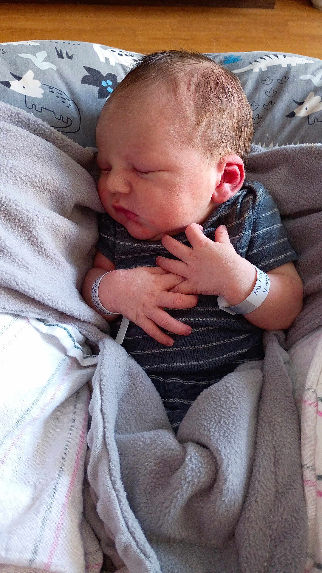 Shadrach is registered to the contest to win money with this photo: baby, blanket, child, close_up, cozy, cute, face, hands, head, hospital_bracelet, indoors, infant, newborn, onesie, peaceful, person, resting, skin, sleeping, soft