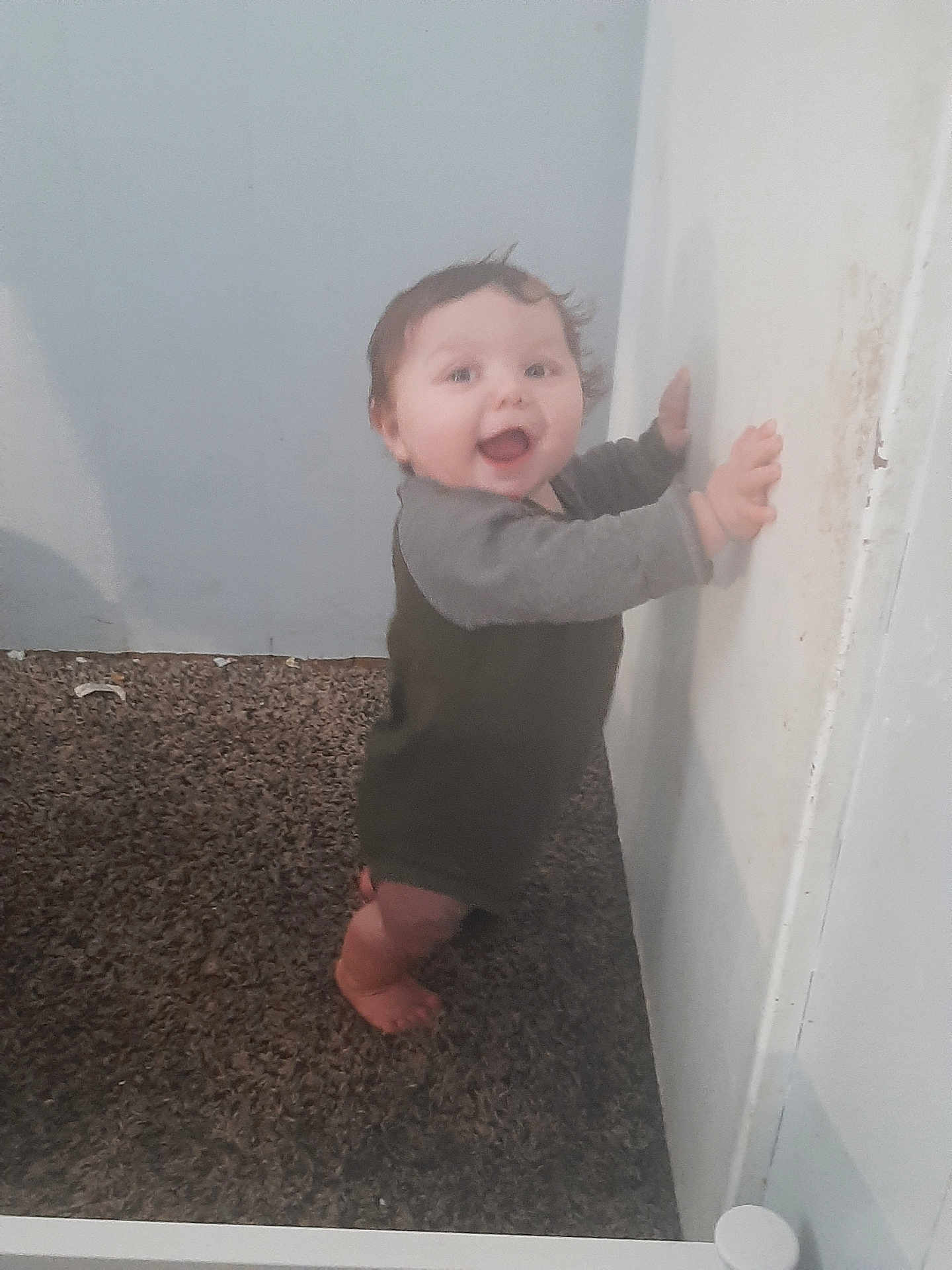 Milo joined the competition — help win amazing prizes! baby, carpet, child, clothing, cute, expression, face, feet, hands, happy, home, indoor, infant, long_sleeve, looking, person, smile, standing, wall, young