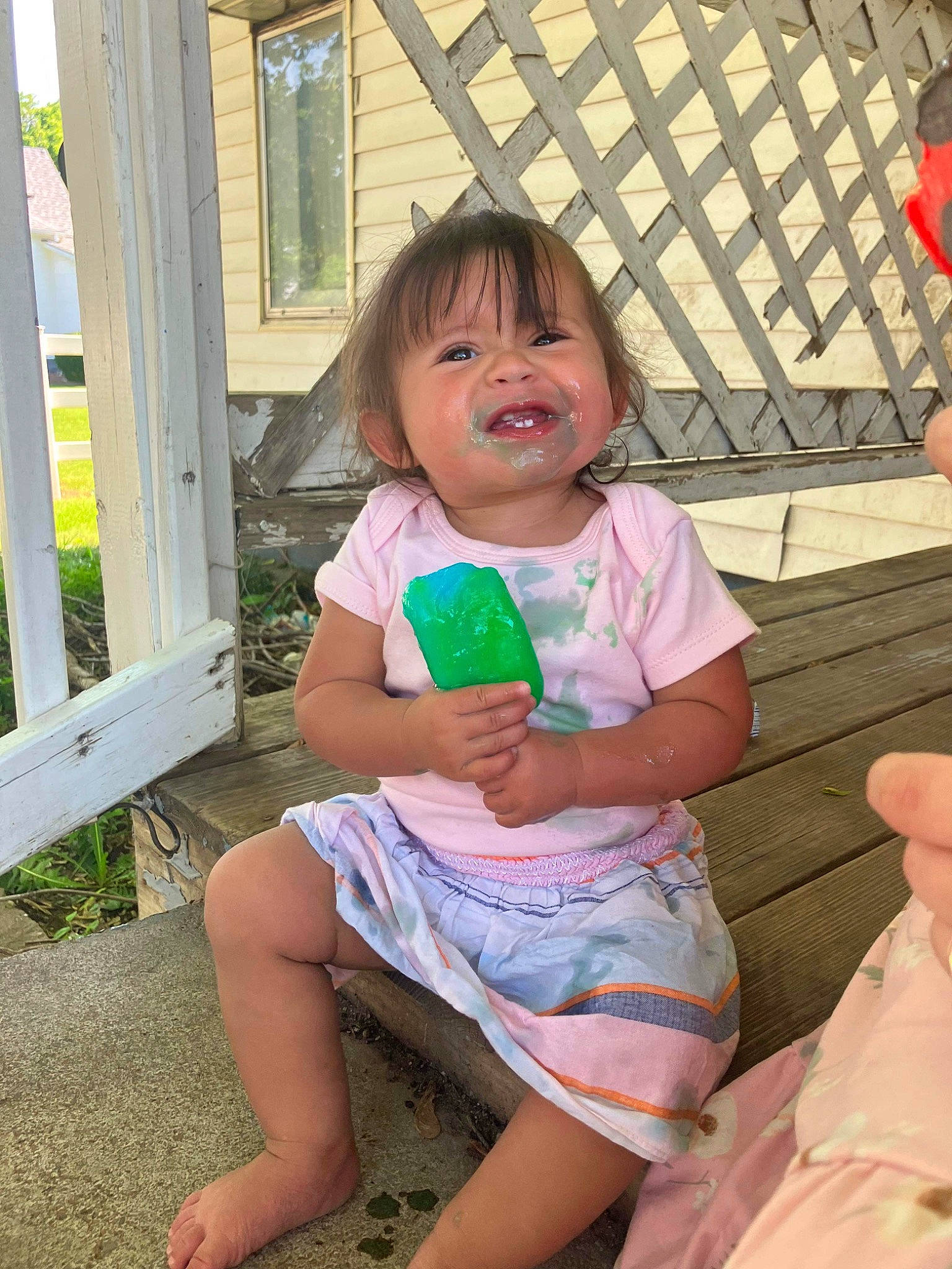Adaliena is registered to the contest to win money with this photo: baby_toddler_clothing, child, finger, foot, fun, grass, hand, happy, human_body, human_leg, leg, leisure, mouth, person, pink, sitting, skin, smile, thigh, thumb