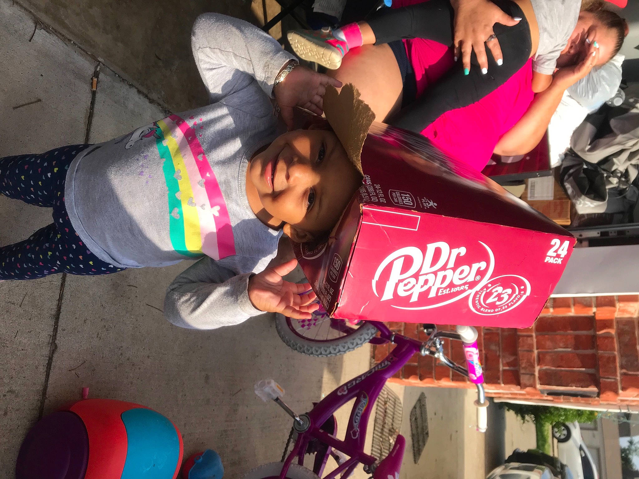 Iyanah is registered to the contest to win money with this photo: bottle, carbonated_soft_drinks, coca_cola, cola, drink, event, fun, headwear, joy, leisure, light, magenta, person, photograph, pink, plant, product, public_space, red, smile