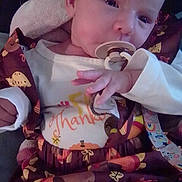 Elaina is registered to the contest to win money with this photo: baby, infant, pacifier, clothing, autumn, turkey, leaves, blanket, hand, face, cute, child, newborn, portrait, sitting, indoors, soft_light, expression, young, cozy