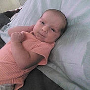 Elaina is registered to the contest to win money with this photo: baby, infant, face, bed, pillow, clothing, person, lying_down, cute, looking, indoors, child, newborn, skin, head, expression, sleepwear, resting, soft, peaceful