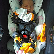 Elaina joined the competition — help win amazing prizes! newborn, baby, car_seat, onesie, sleeping, mittens, orange_socks, child, infant, cute, cozy, unicorn_pattern, heart_pattern, safety_harness, indoor, resting, soft_fabric, plush_padding, peaceful, toddler